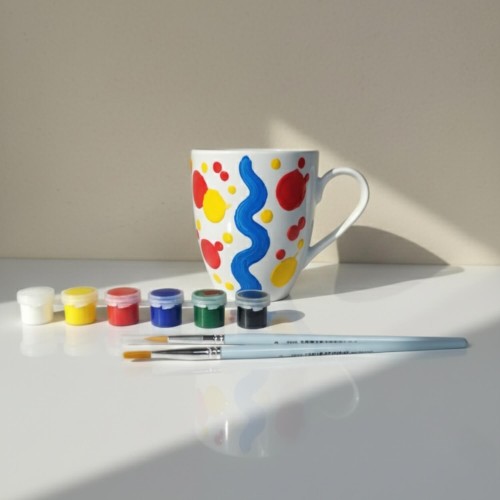 Ręcznie malowany duży kubek w abstrakcyjne, kolorowe wzory – inspiracja do zestawu DIY.