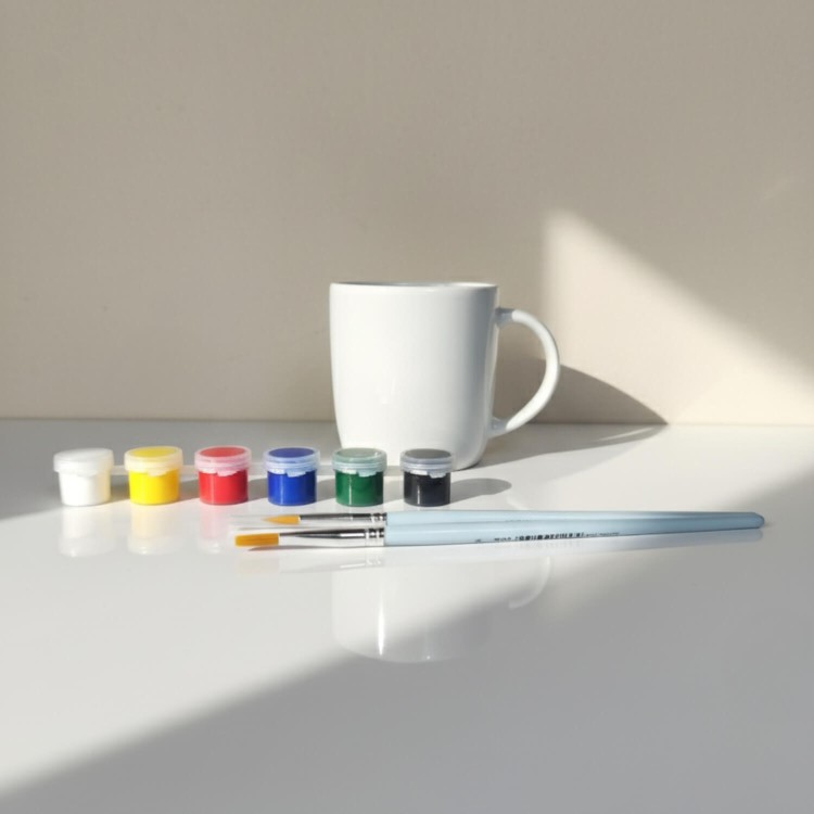 Zestaw DIY do malowania – klasyczny kubek porcelanowy Baza, farby i pędzle.